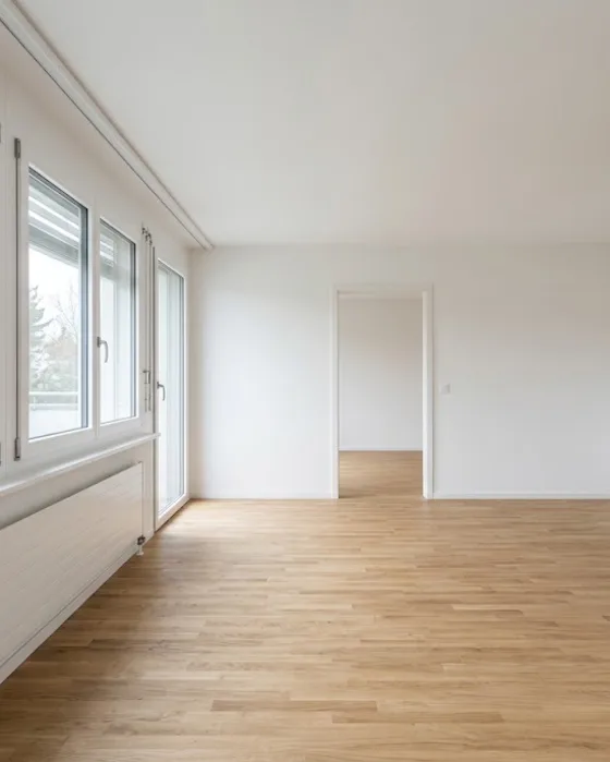 Visualisierung: Leeres, frisch gestrichenes Wohnzimmer mit Parkett und grossen Fenstern